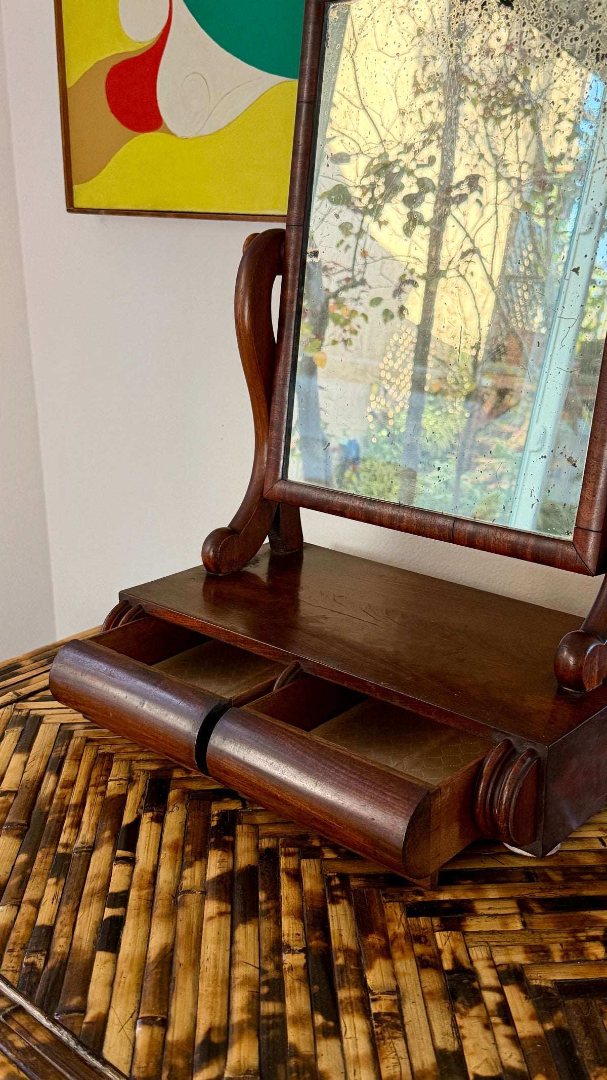 Both drawers of the mahogany dressing mirror pulled open, lined in quilted cream fabric