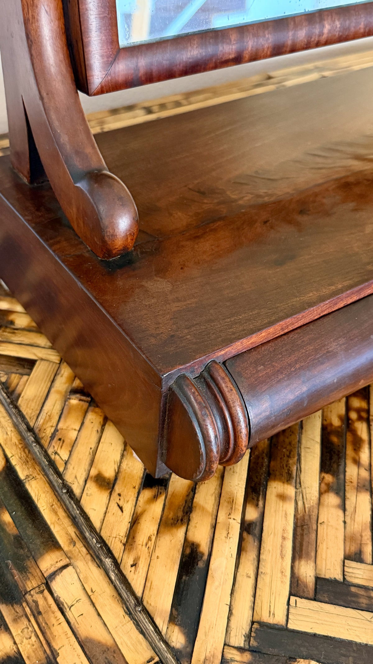 S-scroll supports and turned knobs on which the antique mirror plate tilts