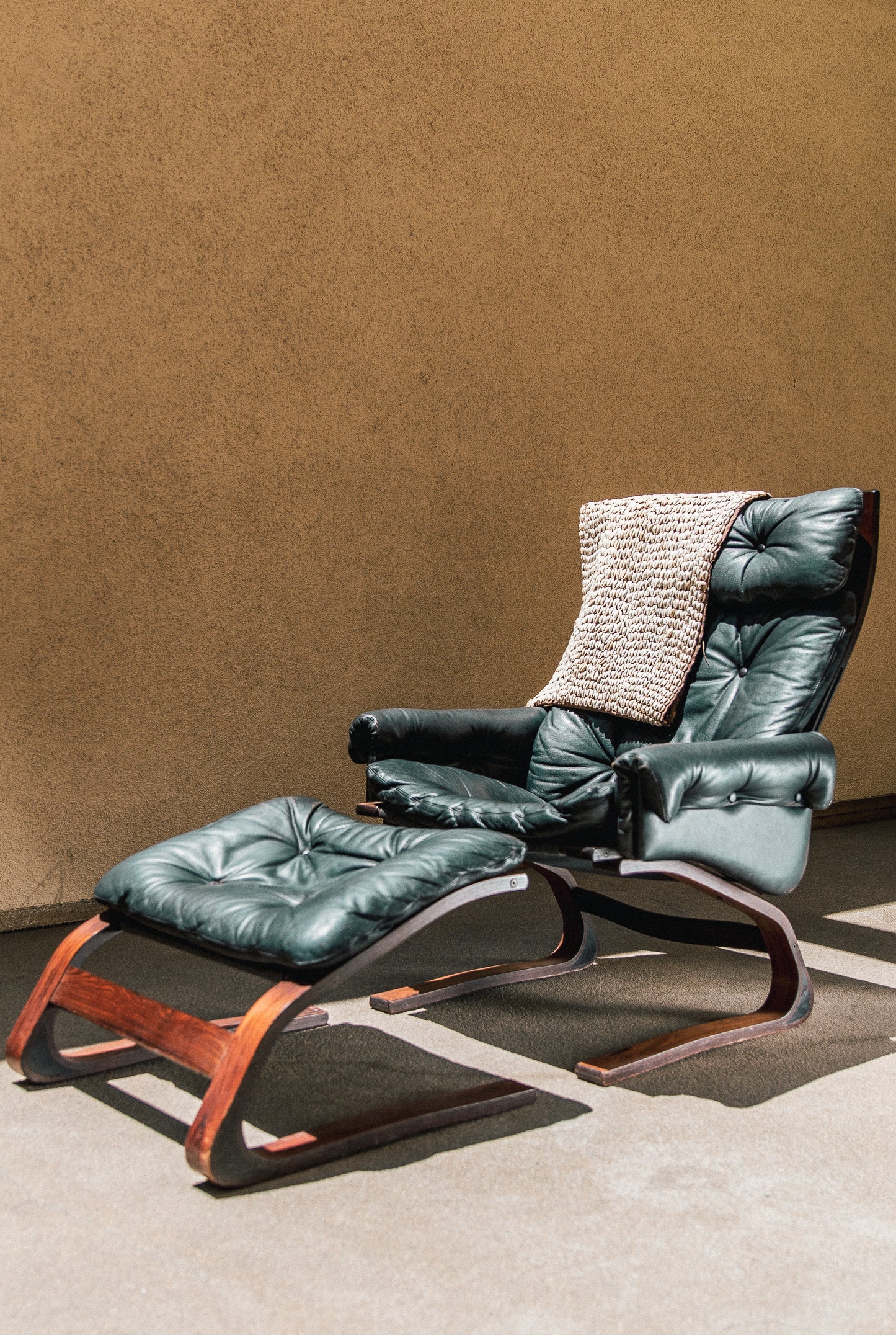 Side profile of the Kengu lounge chair showing the continuous bent rosewood frame