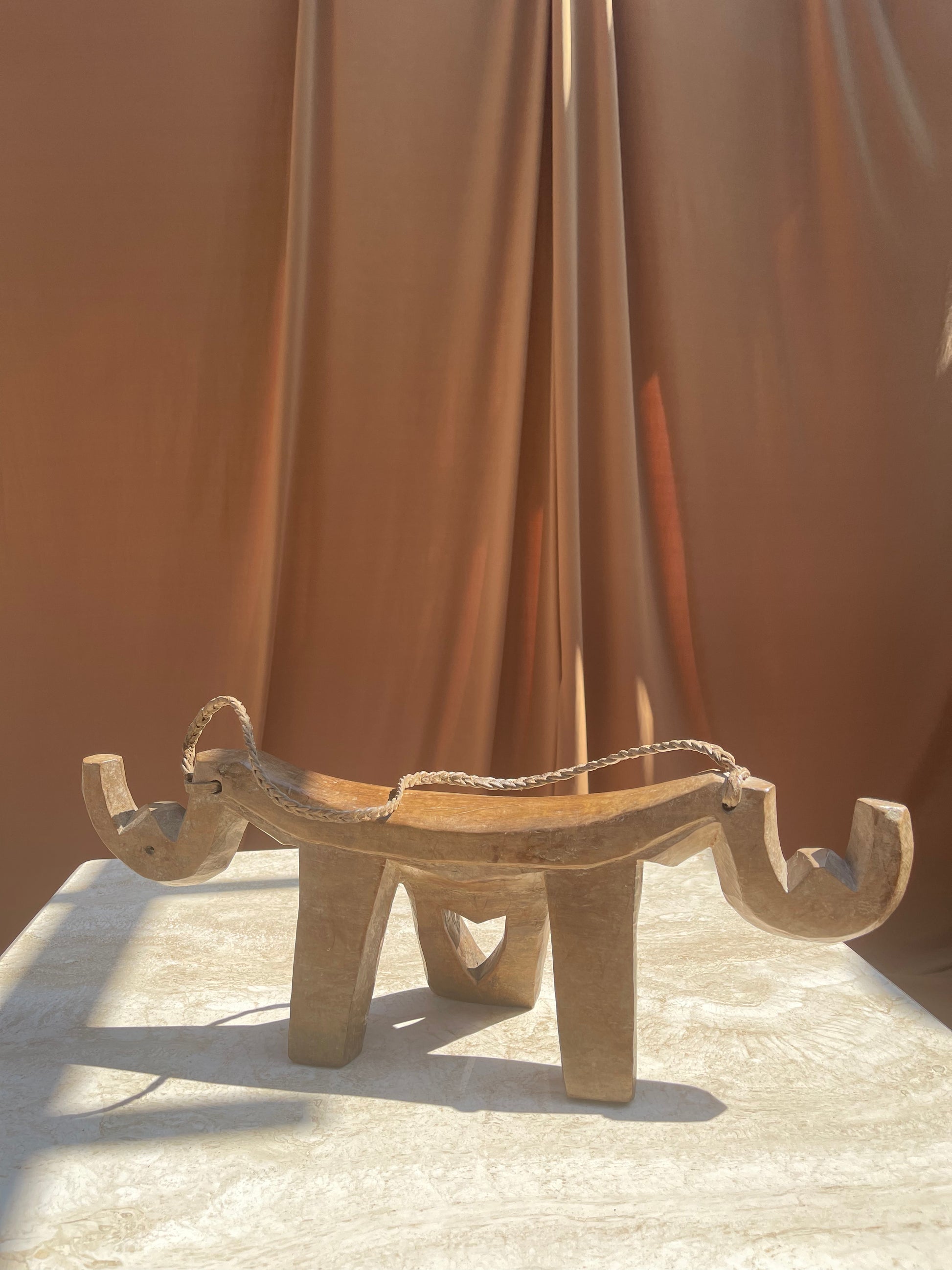 Antique Lobi stool showing the carved single-block form and patina