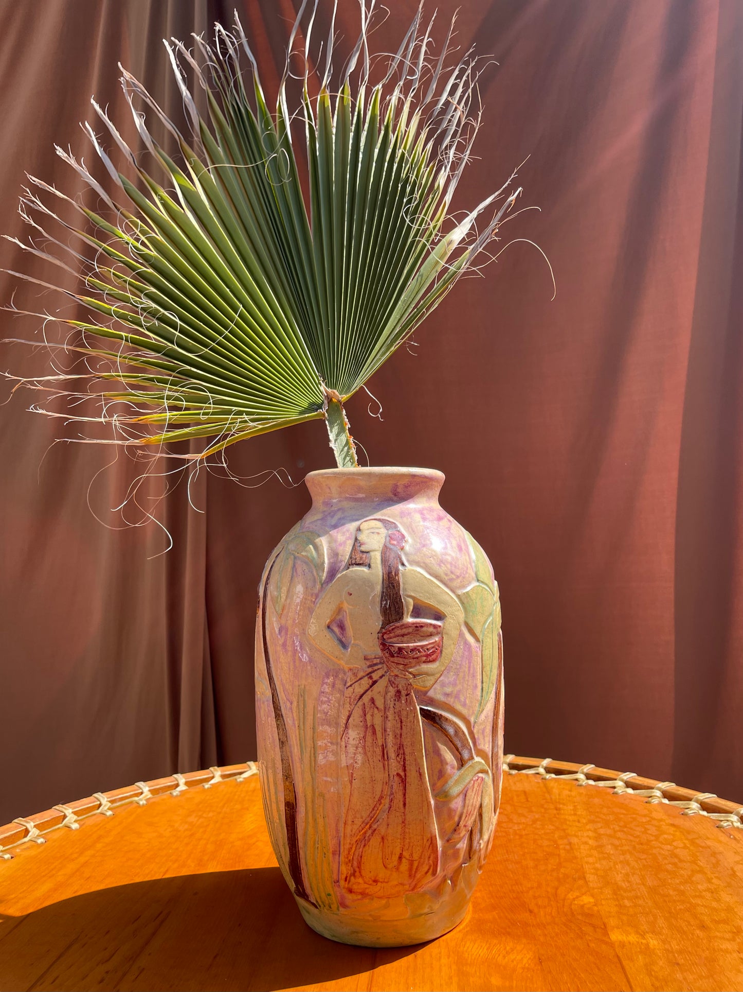 Vintage ceramic vase showing hand-painted palm frond detail